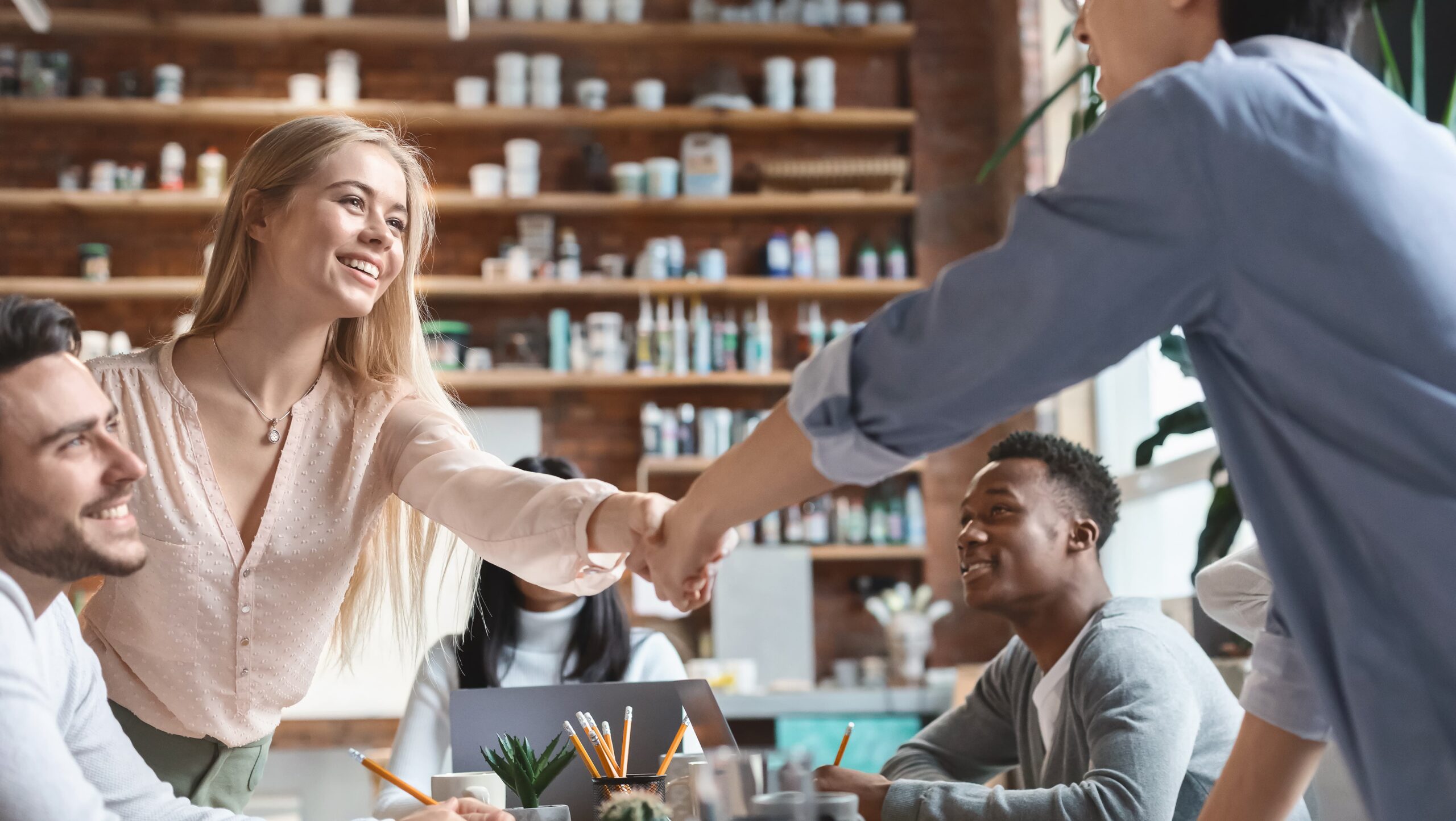 Team members shaking hands, highlighting customer retention strategies built on trust, communication, and strong relationships.